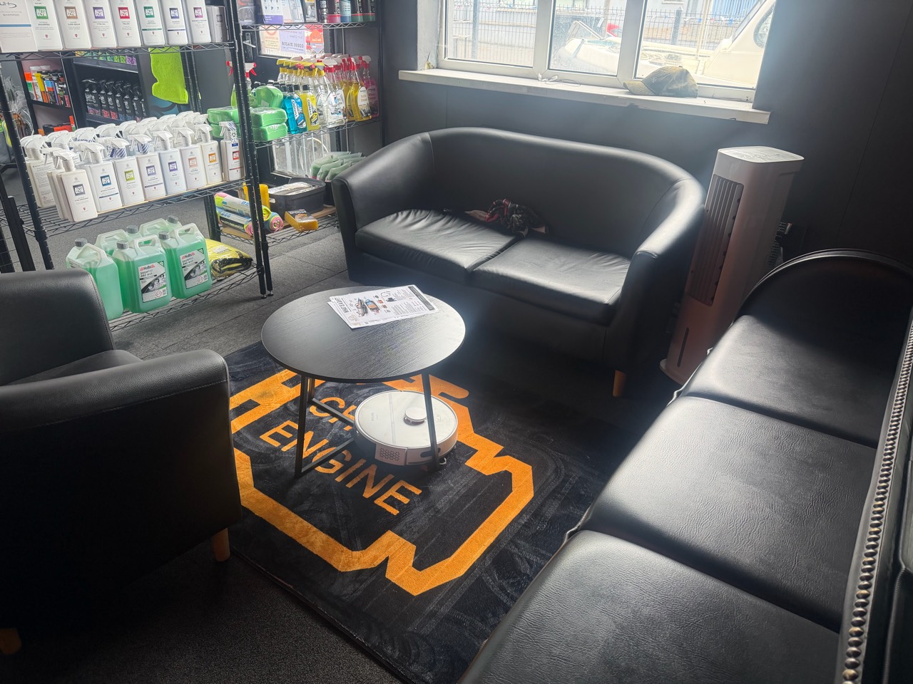 Customer waiting area with seating and in-store car care products at Prestige Performance Group